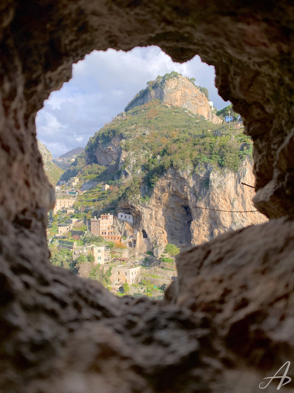 The view through a hole in the wall of the town of Atrani, Italy, below.