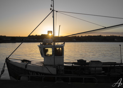 Boat docked as the sun sets in Cahore, Wexford County, Ireland