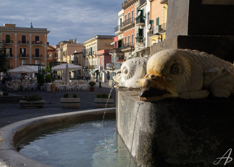 Two statues from a water fountain overlooking the town of Pozzuoli, Italy.
